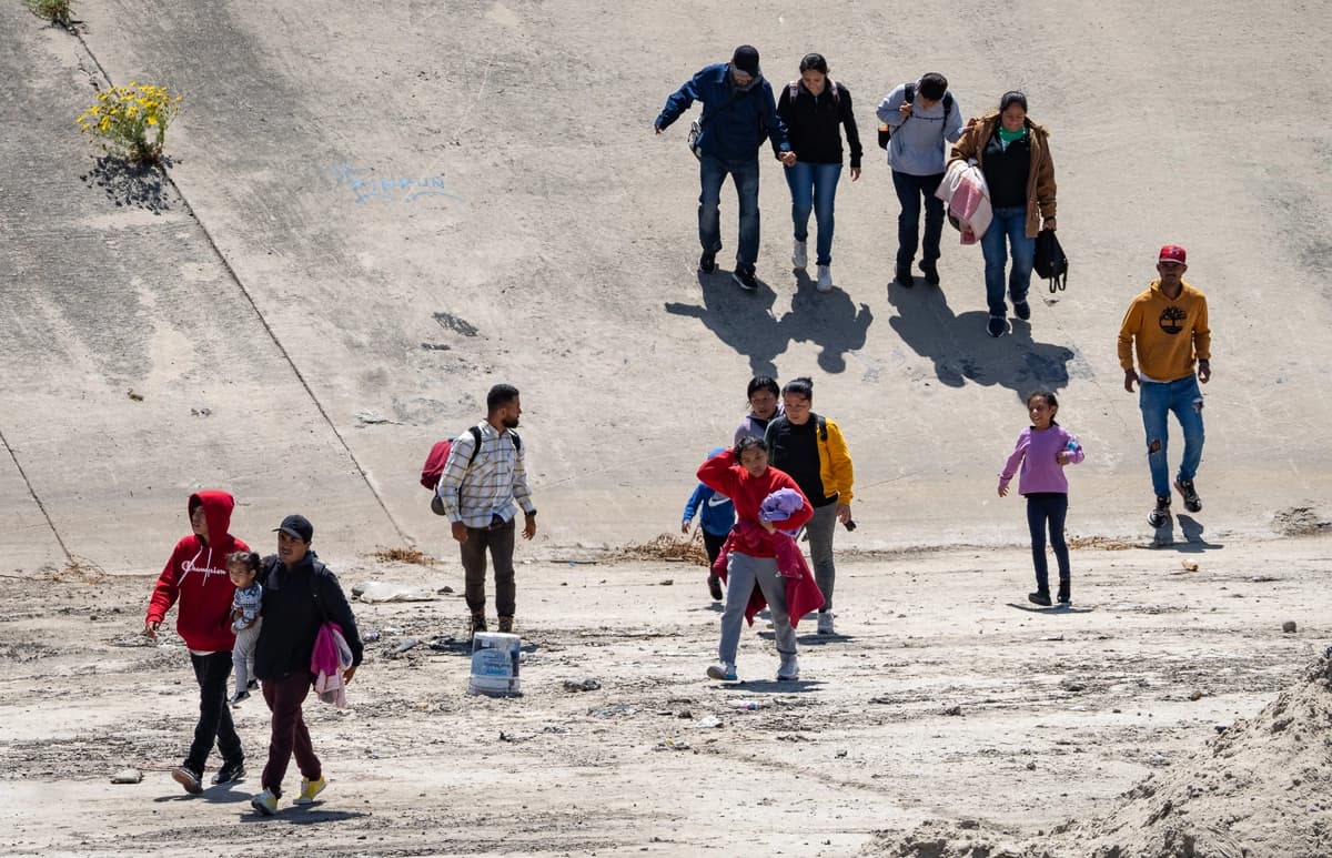 Personas cruzan el río Tijuana y se dirigen hacia el muro fronterizo con Estados Unidos en Tijuana, México, el 11 de mayo de 2023. (John Fredricks/The Epoch Times).