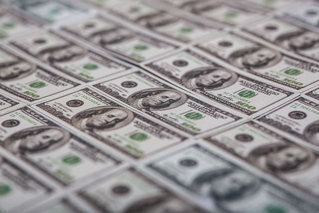 Billetes de 100 dólares estadounidenses extendidos sobre una mesa. (Foto de Romain Costaseca/Hans Lucas/AFP vía Getty Images)