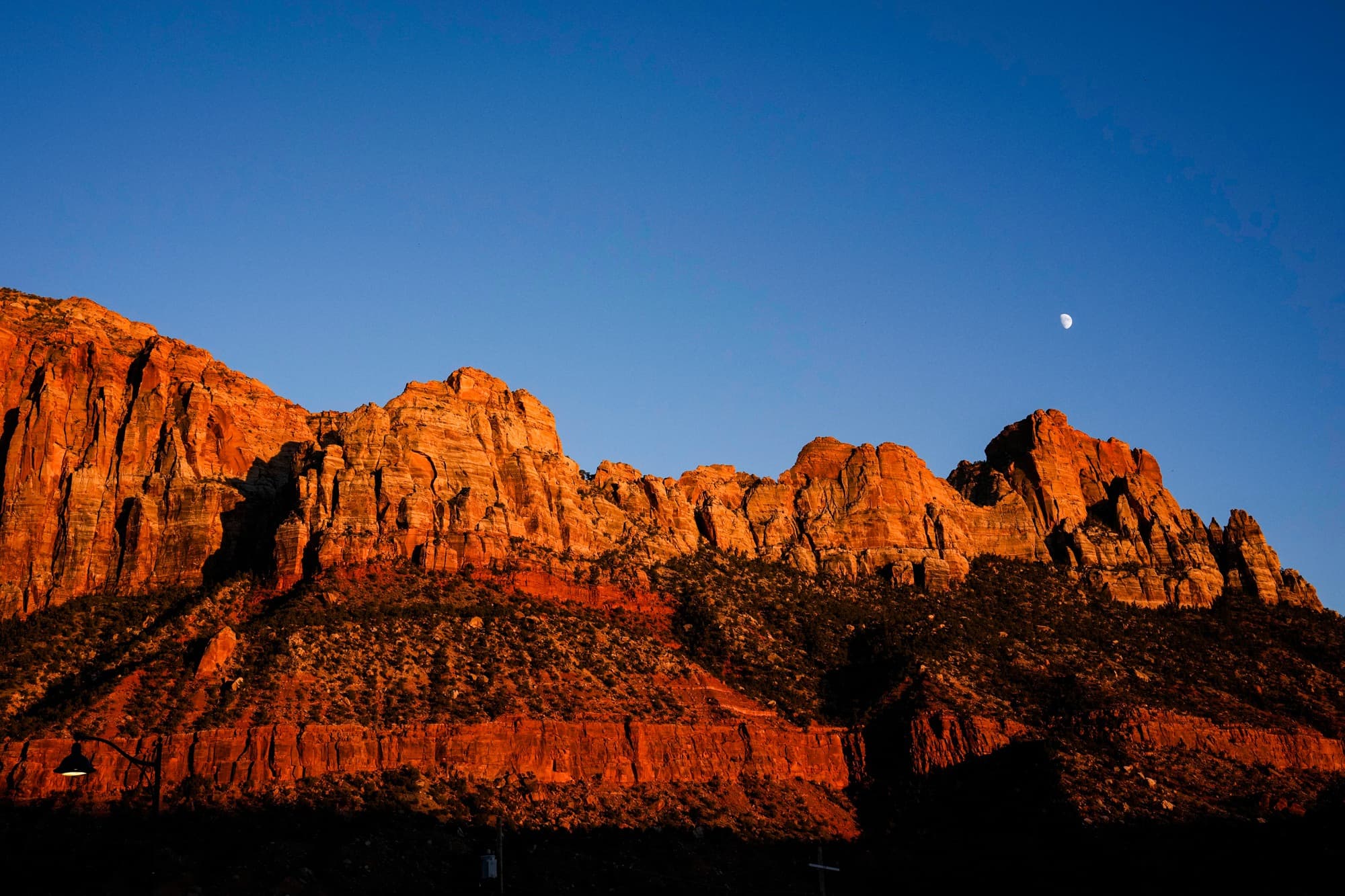 La luna se eleva sobre un acantilado de arenisca en el Parque Nacional Zion, cerca de Springdale, Utah, el 1 de octubre de 2025. Al menos 18 parques nacionales de EE. UU. han sido designados Parques Internacionales de Cielo Oscuro por sus cielos excepcionalmente oscuros y sus excelentes condiciones para la observación de estrellas. (John Locher/AP).