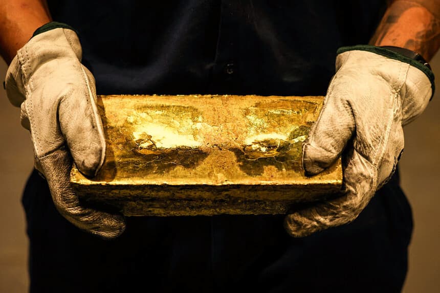 Un refinador sostiene un lingote de oro tras haberlo extraído de un molde en la fundición, el 29 de abril de 2025. Imagen ilustrativa (DAVID GRAY/AFP vía Getty Images)