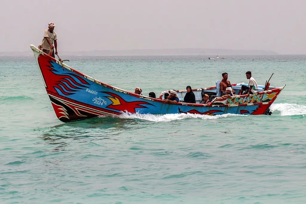 Unas personas se encuentran sentadas en un barco pesquero que navega por el estrecho de Bab el-Mandeb, frente a la costa de la provincia de Taiz, al sur de Yemen, el 25 de julio de 2026. (Khaled Ziad/AFP vía Getty Images).