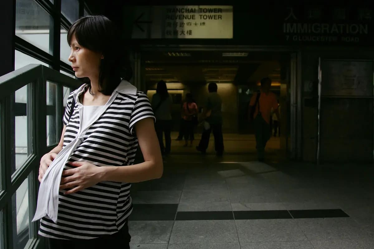 <em>Una mujer embarazada se encuentra frente a la entrada del Departamento de Inmigración de Hong Kong, en Hong Kong, el 29 de junio de 2007. (MN Chan/Getty Images).</em>