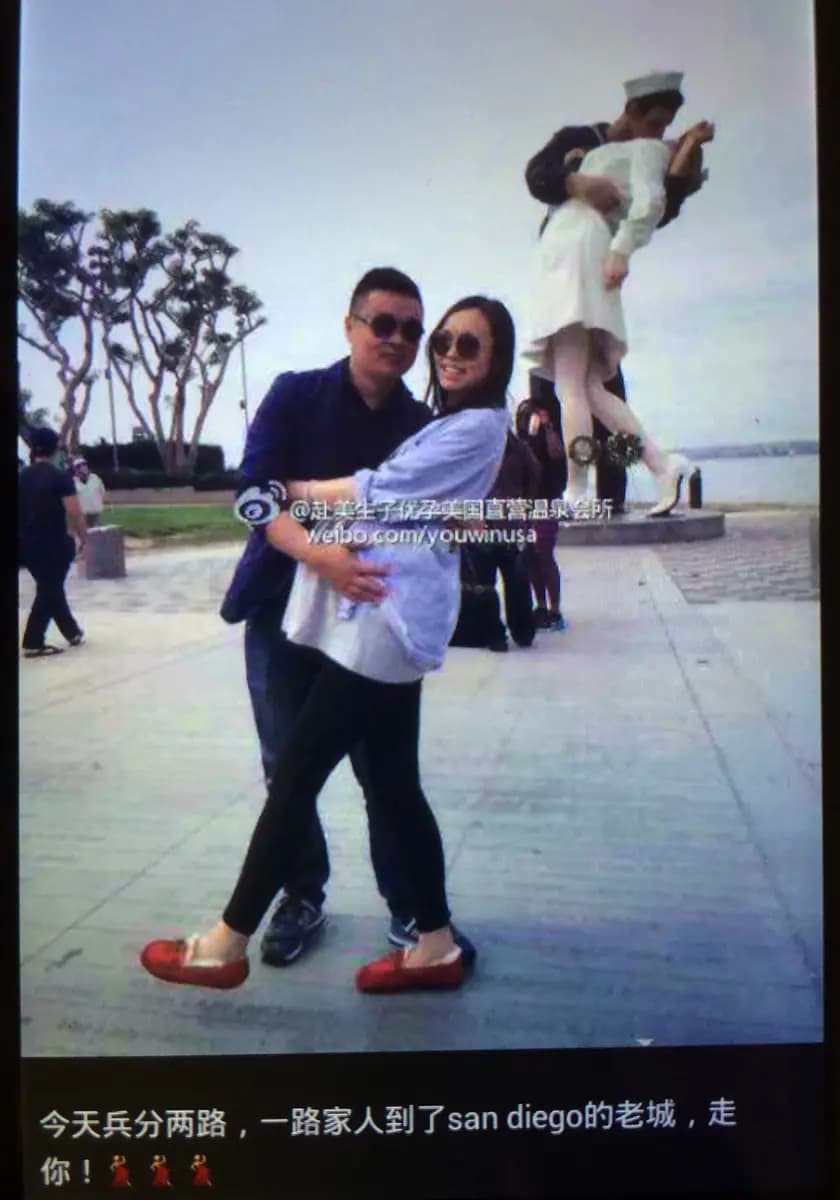 <em>Un hombre y una mujer china embarazada posan frente a una estatua en una fotografía titulada "Ganaste". (Cortesía del Servicio de Inmigración y Control de Aduanas de Estados Unidos).</em>