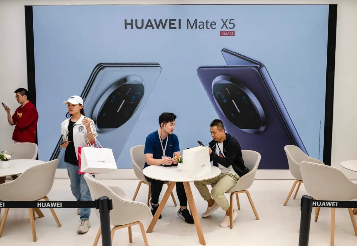 Un cliente habla con un dependiente mientras recoge un nuevo teléfono inteligente Mate 60 en una tienda insignia de Huawei, después de que la empresa presentara nuevos productos en Pekín, China, el 25 de septiembre de 2023. (Kevin Frayer/Getty Images)