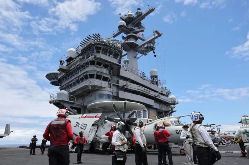 Miembros de la tripulación de la cubierta de vuelo observan despegar a los aviones de combate desde el portaaviones USS Carl Vinson durante los ejercicios militares Rim of the Pacific (RIMPAC) a unas 100 millas al sur de Oahu, Hawái, el 19 de julio de 2024. (Marco García/Foto de archivo/Reuters)