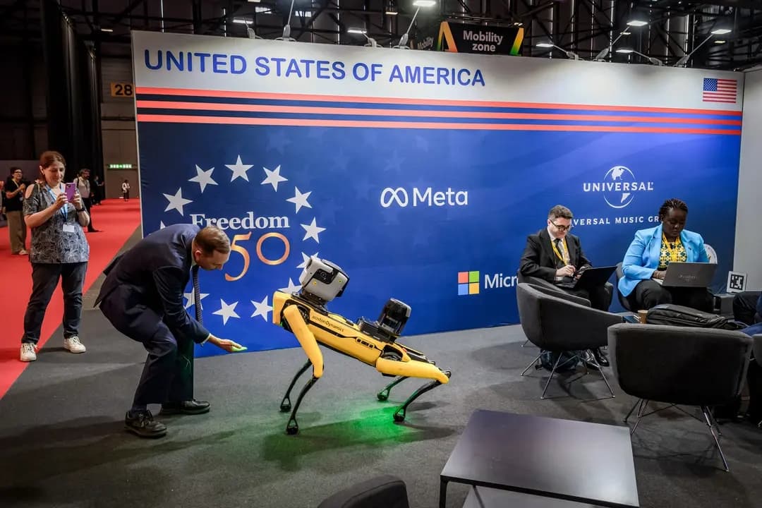 Un visitante interactúa con un robot con apariencia de perro de Boston Dynamics en el pabellón de EE. UU. durante la Cumbre Global “AI for Good” en Ginebra, el 7 de julio de 2026. (Fabrice Coffrini/AFP vía Getty Images)