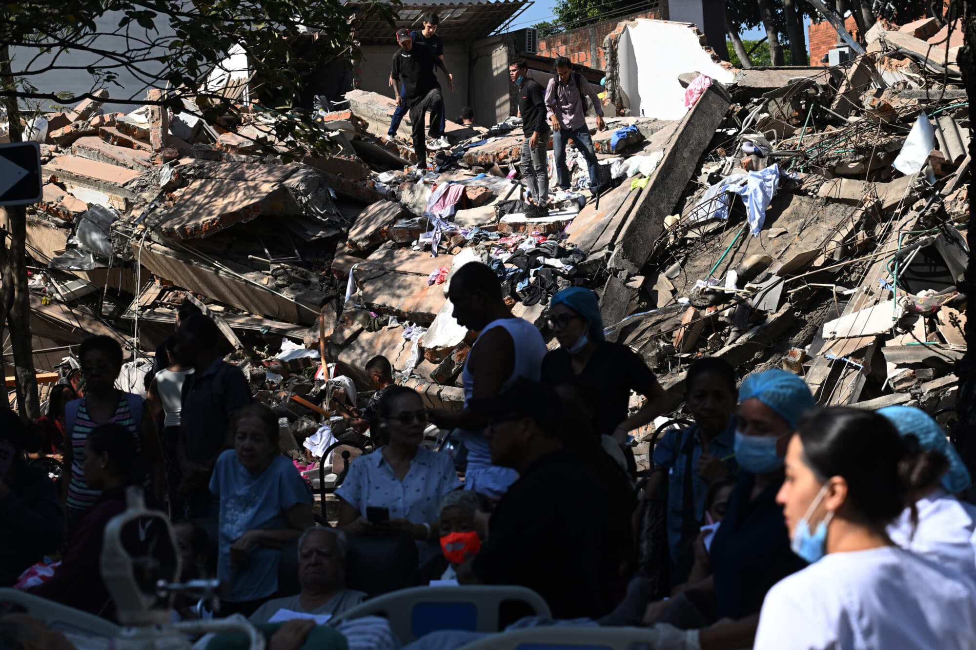 La gente busca sobrevivientes entre los escombros de un edificio derrumbado tras un terremoto en Cali, Colombia, el 10 de agosto de 2026. Un potente terremoto sacudió a Colombia y a los países vecinos de América Latina el 10 de agosto de 2026, y los equipos médicos se apresuraron a ayudar a las víctimas después de que varios edificios resultaran dañados o se derrumbaran en varias ciudades. El Servicio Geológico de Colombia y su contraparte estadounidense, el USGS, estimaron la magnitud en 7.4, con un epicentro a 100 km (60 millas) de profundidad en el oeste del país. Colombia la había estimado inicialmente en 6.6. (Joaquín SARMIENTO / AFP vía Getty Images)