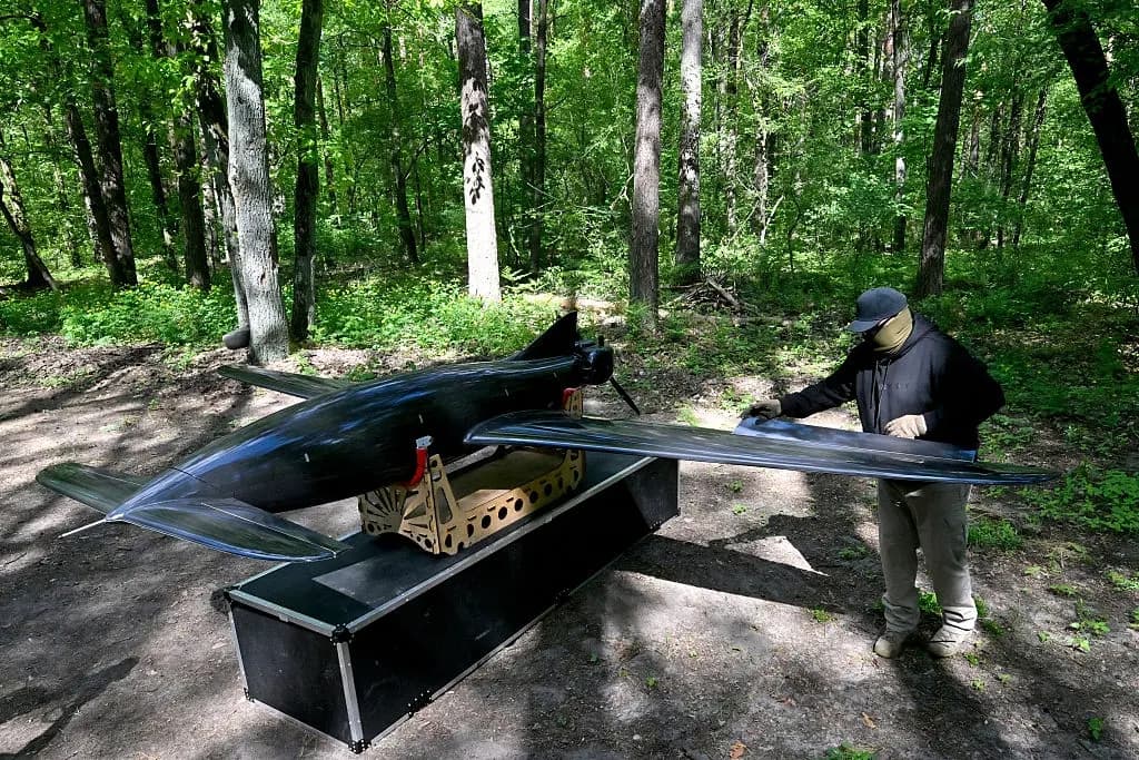 Esta fotografía, tomada en un lugar no revelado de Ucrania, muestra a un militar ucraniano de la Dirección General de Inteligencia del Ministerio de Defensa de Ucrania trabajando en un dron Bober o "Beaver", utilizado para llevar a cabo ataques en profundidad en territorio ruso, el 16 de mayo de 2026. (Sergei Supinsky/AFP vía Getty Images)