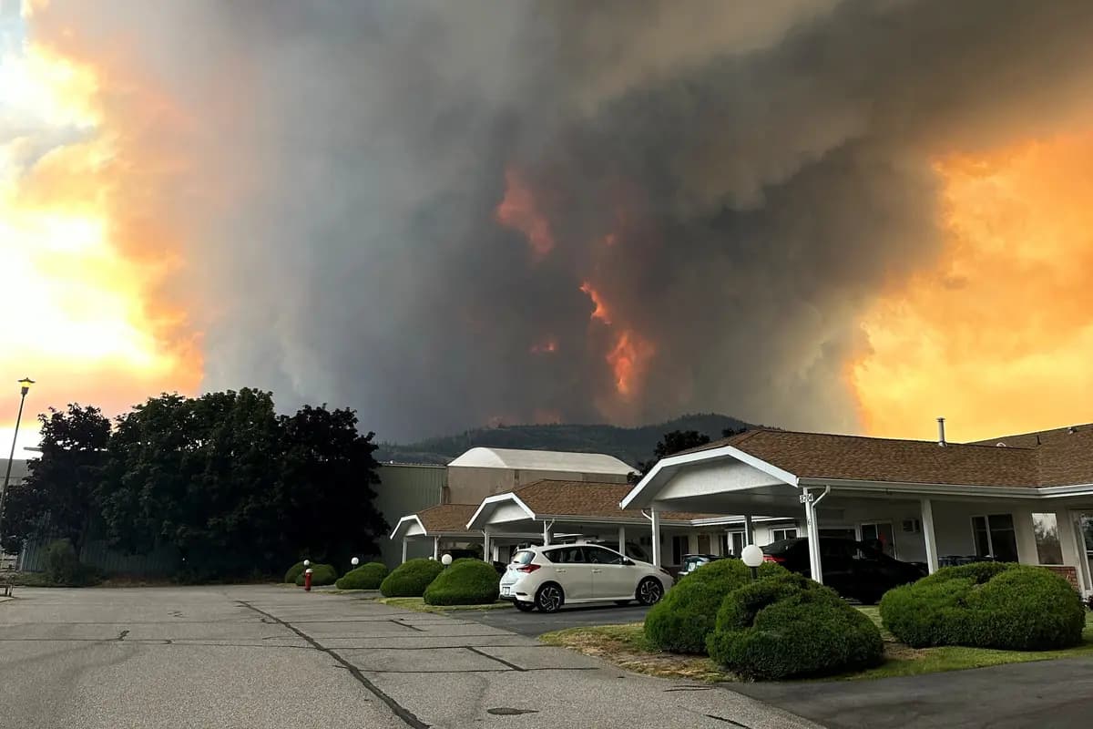 <em>El humo del incendio forestal de Bald Range se eleva sobre una calle residencial en Summerland, Columbia Británica, el 7 de agosto de 2026. (Terry Fries/Imagen cedida a través de Reuters).</em>