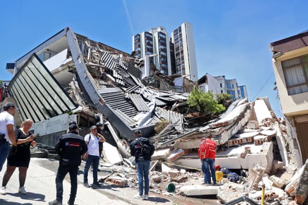 Varias personas permanecen cerca de un edificio derrumbado tras un terremoto en Manizales, Colombia, el 10 de agosto de 2026. (Foto de Giovanny Galvez / AFP vía Getty Images)