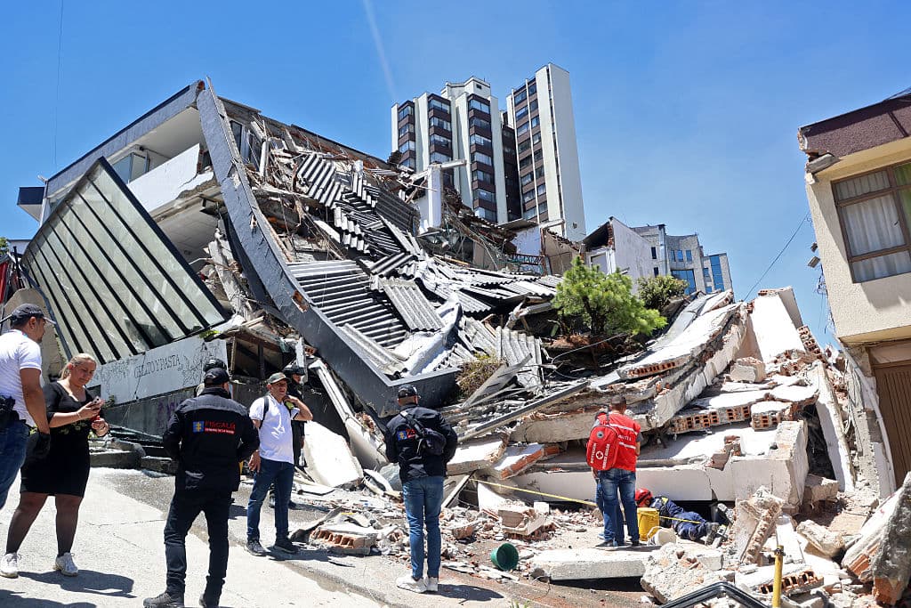 Varias personas permanecen cerca de un edificio derrumbado tras un terremoto en Manizales, Colombia, el 10 de agosto de 2026. (Foto de Giovanny Galvez / AFP vía Getty Images)