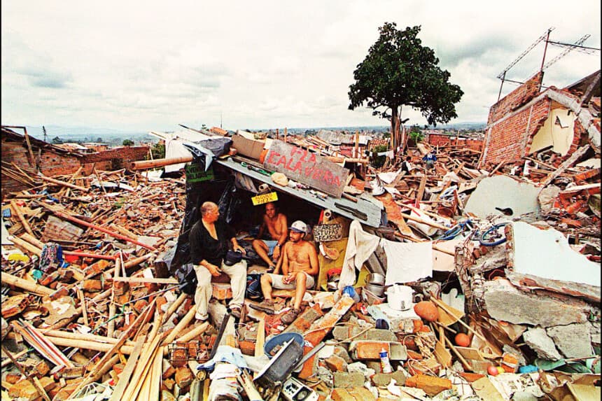 Las víctimas del terremoto del 25 de enero se refugian en una choza improvisada entre los escombros que quedaron en Armenia, Colombia, el 1 de febrero de 1999. (MARCELO SALINAS/AFP vía Getty Images)