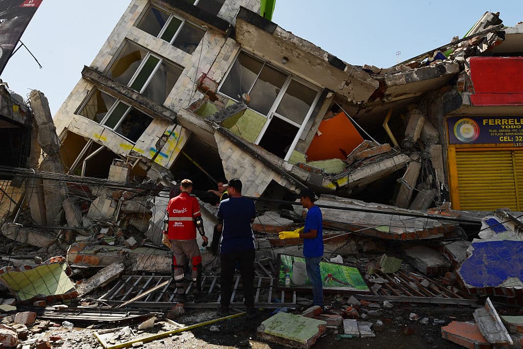 Personas buscan sobrevivientes entre los escombros de un edificio derrumbado tras un terremoto en Pereira, Colombia, el 10 de agosto de 2026. Un potente sismo sacudió Colombia y países latinoamericanos vecinos el lunes 10 de agosto de 2026, y equipos médicos se apresuraron a ayudar a las víctimas tras los daños y derrumbes de edificios en varias ciudades. (Jaime SALDARRIAGA / AFP vía Getty Images)