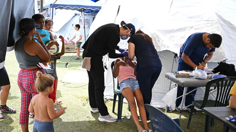 <em>Personal médico atiende a un niño en un refugio en el estadio de béisbol César Nieves, en el barrio La Angustia de Catia La Mar, La Guaira, Venezuela, el 8 de julio de 2026, El 8 de julio de 2026, el gobierno de Venezuela solicitó la liberación de activos congelados para ayudar a recaudar fondos destinados a la recuperación del país. (Raul ARBOLEDA / AFP vía Getty Images)</em>