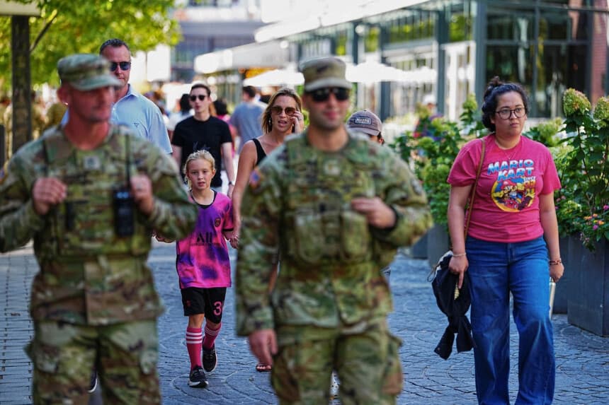Varias personas caminan por la calle cerca de miembros de la Guardia Nacional después de que el presidente estadounidense Donald Trump desplegara la Guardia Nacional y ordenara una mayor presencia de las fuerzas del orden federales para ayudar en la prevención del delito, en Washington, el 23 de agosto de 2025. (Aaron Schwartz/Reuters).