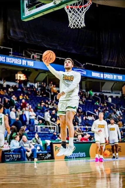 Luke Cecchi realiza el calentamiento antes de un partido en 2025. Educado en casa durante toda la preparatoria, Cecchi se ganó un lugar como jugador sin beca en el equipo masculino de baloncesto de la División I de la NCAA de la Universidad de Siena, después de que lo rechazaran en las pruebas de selección para los equipos locales de fútbol y baloncesto de preparatoria. (Cortesía de Luke Cecchi)