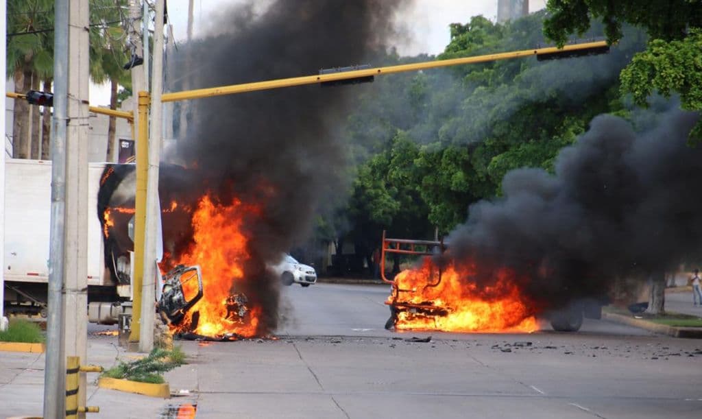 Vehículos arden en una calle de Culiacán, Sinaloa, México, el 17 de octubre de 2019. Hombres fuertemente armados, a bordo de camionetas todoterreno, se enfrentaron en un intenso combate con las fuerzas de seguridad mexicanas en Culiacán, capital del estado natal de Joaquín "el Chapo" Guzmán, entonces encarcelado. (STR/AFP vía Getty Images)