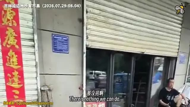 <em>El dueño de una tienda se sienta en cuclillas frente a su local, cuya persiana está parcialmente abajo, en Yanbian, provincia de Jilin, mientras los negocios aledaños permanecen cerrados. (Cortesía de YesterdayBigcat/Captura de pantalla vía The Epoch Times).</em>