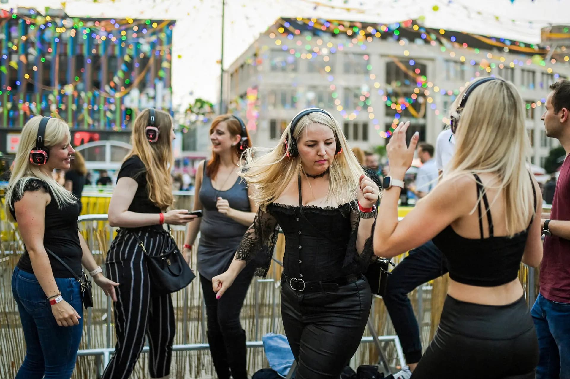 Los participantes sintonizan varios canales con sus audífonos inalámbricos durante un evento llamado "Headphone Disco" en la plaza Kennedyplatz de Essen, Alemania, el 9 de julio de 2021. El auge de los contenidos digitales ofrece numerosas opciones a los amantes de la música de hoy en día. (Ina Fassbender / AFP vía Getty Images).