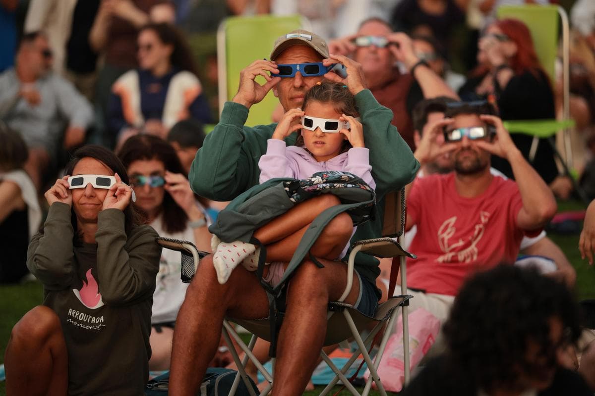 Personas con gafas especiales para eclipses solares observan el eclipse solar total en el parque El Monte de San Pedro, en A Coruña, España, el 12 de agosto de 2026. Fue la primera vez desde 1905 que se pudo observar desde España un eclipse solar total, en el que la Luna bloquea el Sol al pasar por su órbita. (Chip Somodevilla/Getty Images)