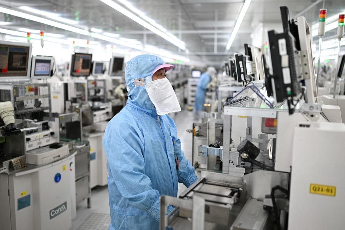 Técnicos trabajan en equipos de procesamiento de chips en una planta de fabricación de semiconductores en Suqian, en la provincia de Jiangsu, al este de China, el 20 de octubre de 2025. (STR/AFP vía Getty Images)