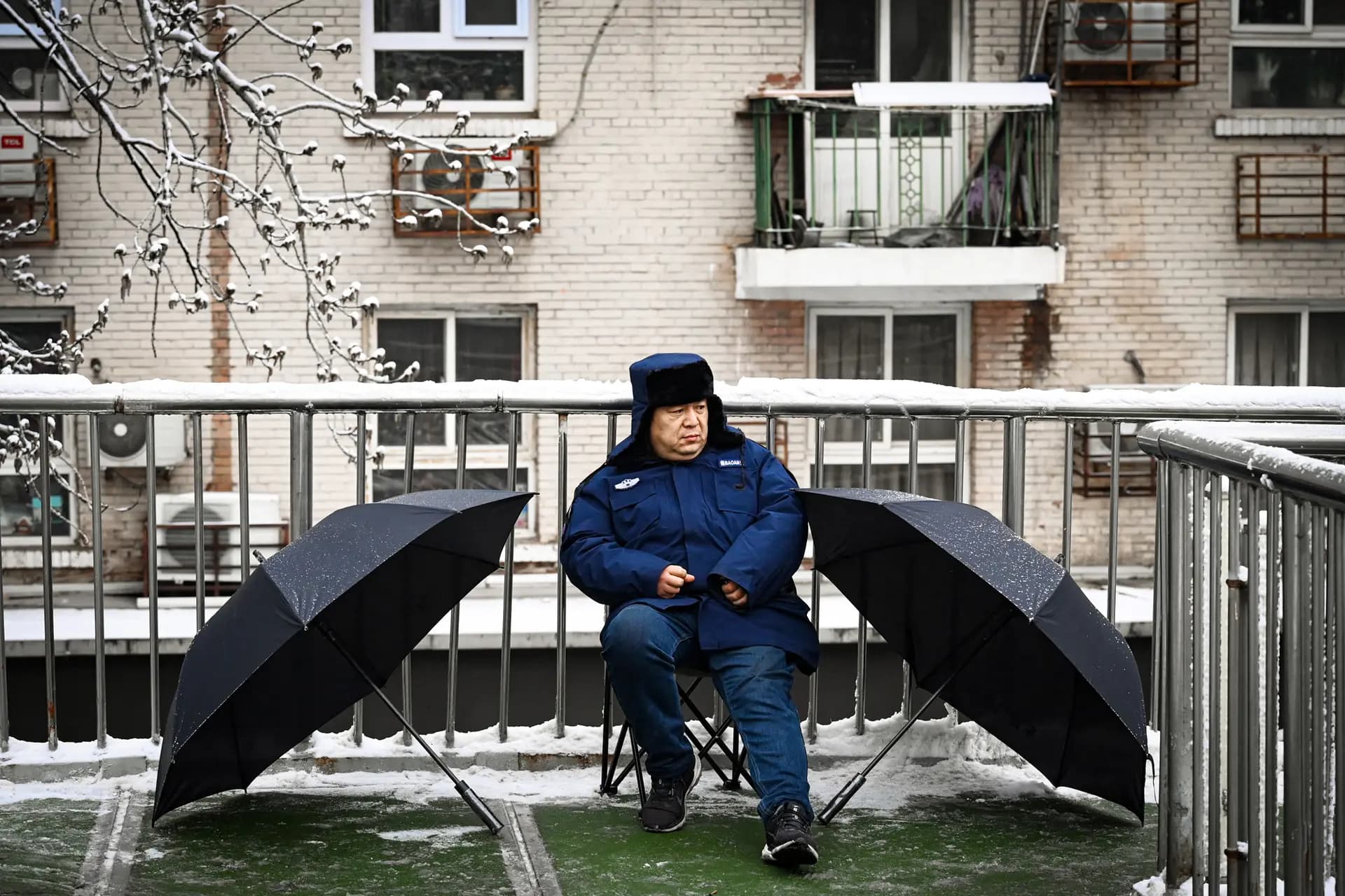 Un guardia de seguridad vigila un paso elevado para peatones mientras se celebraba la sesión inaugural de la Asamblea Popular Nacional en Beijing el 5 de marzo de 2026. (Greg Baker/AFP vía Getty Images).