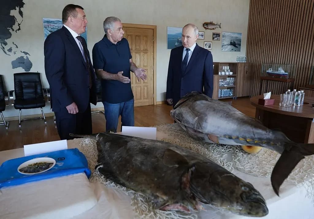 El presidente de Rusia, Vladimir Putin (derecha), visita la planta procesadora de pescado Yasny en la isla de Iturup, una de las cuatro islas del archipiélago en disputa conocido como las Islas Kuriles en Rusia y los Territorios del Norte en Japón, el 13 de agosto de 2026. (Gavriil Grigorov/AFP vía Getty Images)