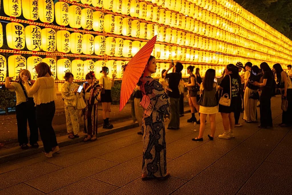La gente se reúne frente a miles de linternas expuestas durante el Mitama Matsuri, uno de los festivales de "obon" de verano más grandes de la capital, en el Santuario de Yasukuni en Tokio el 15 de julio de 2026. (Philip Fong/AFP vía Getty Images)
