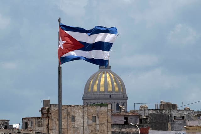 La bandera cubana ondea en el Malecón de La Habana, con el Capitolio al fondo, el 18 de junio de 2026. (Pablo PORCIUNCULA / AFP vía Getty Images)