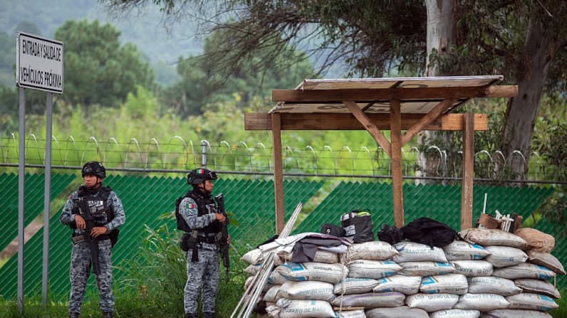 <em>Miembros de la Guardia Nacional montan guardia en un punto de acceso a Uruapan, en el estado mexicano de Michoacán, el 7 de agosto de 2026, como parte de las medidas de seguridad implementadas por las autoridades en la región tras el despliegue de 1500 efectivos militares, motivado por la suspensión de las exportaciones de aguacate a Estados Unidos debido a preocupaciones de seguridad. Estados Unidos suspendió las importaciones procedentes del mayor productor de aguacate de México por motivos de seguridad, según anunció una asociación del sector el 5 de agosto de 2026. El estado de Michoacán, azotado por la violencia, es el principal exportador de esta fruta a Estados Unidos. El gobierno estatal calificó la suspensión como una "medida preventiva" tras la detención de líderes criminales conocidos por extorsionar a la industria aguacatera de la región (Enrique Castro / AFP vía Getty Images).</em>