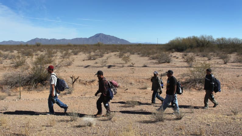 <em>Foto de archivo que muestra Inmigrantes mexicanos indocumentados caminando por el desierto de Sonora tras cruzar ilegalmente la frontera entre Estados Unidos y México el 19 de enero de 2011, entrando en el territorio de la Nación Tohono O'odham, en Arizona. Los inmigrantes relataron que habían vagado perdidos por el desierto durante una semana después de cruzar desde México hacia la vasta reserva indígena durante la noche. Exhaustos, solicitaron a la Patrulla Fronteriza que los recogiera y los llevara a la frontera entre Estados Unidos y México, desde donde regresarían a sus hogares en el estado mexicano de Sonora. Según explicaron, habían llegado con la intención de alcanzar Phoenix y encontrar trabajo en la construcción o en el sector de jardinería y paisajismo. Todos afirmaron haber trabajado anteriormente en Arizona. (John Moore/Getty Images)</em>