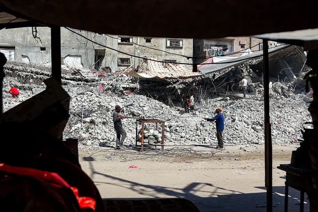 Trabajadores de recuperación desmontan barras de acero de los escombros de un edificio que fue destruido durante la guerra de Israel contra Hamás en Gaza, con el fin de utilizar los restos reciclados en el futuro, en la ciudad de Gaza el 16 de agosto de 2026. (Omar Al-Qattaa/AFP vía Getty Images).