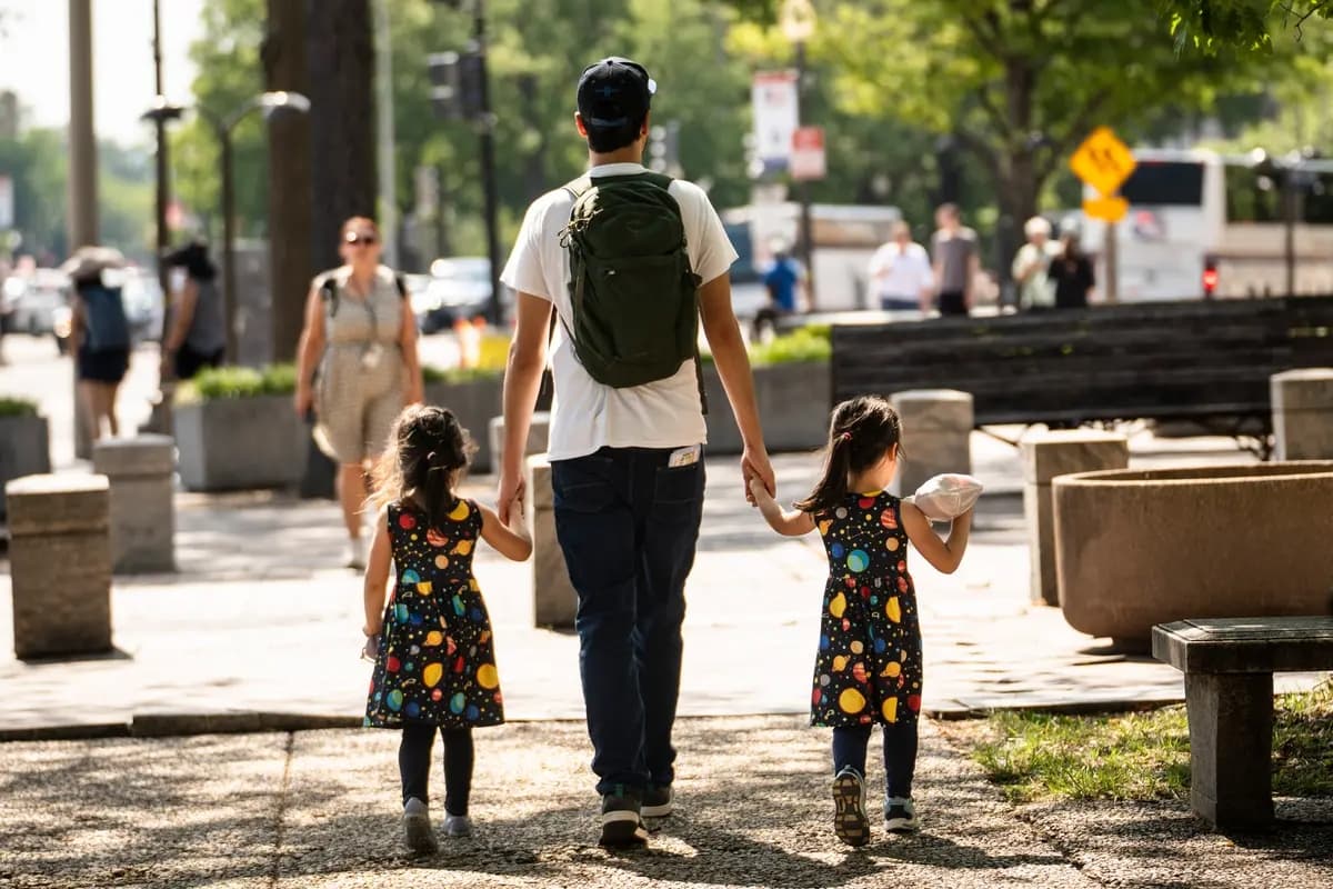 (Un hombre con niños camina en Washington el 13 de julio de 2026. Madalina Kilroy/The Epoch Times)