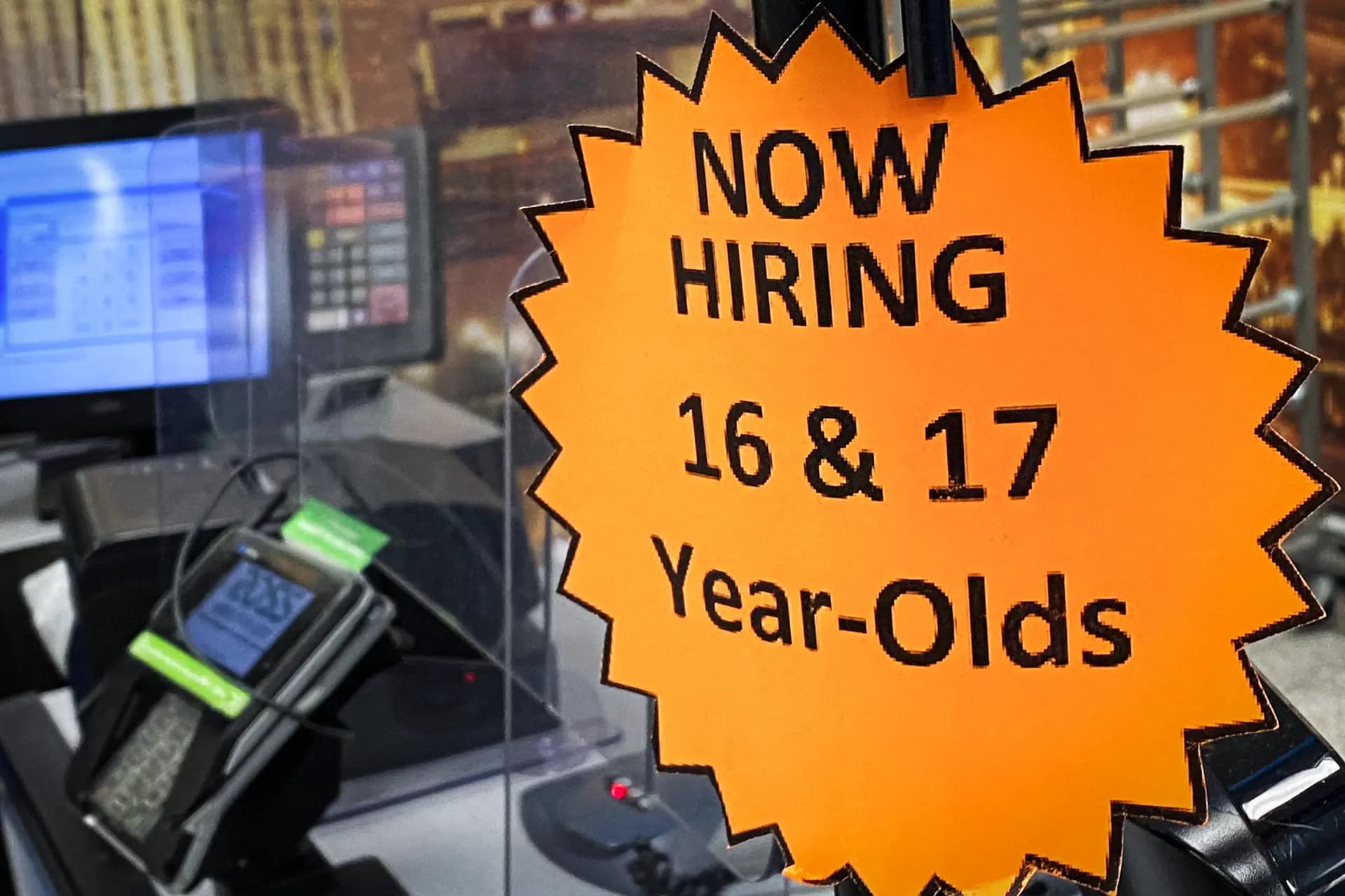 El 7 de mayo de 2022, se exhibe un letrero de contratación para empleados de 16 y 17 años en una caja registradora dentro de una tienda departamental de descuento en Las Vegas, Nevada. (Patrick T. Fallon/AFP vía Getty Images).