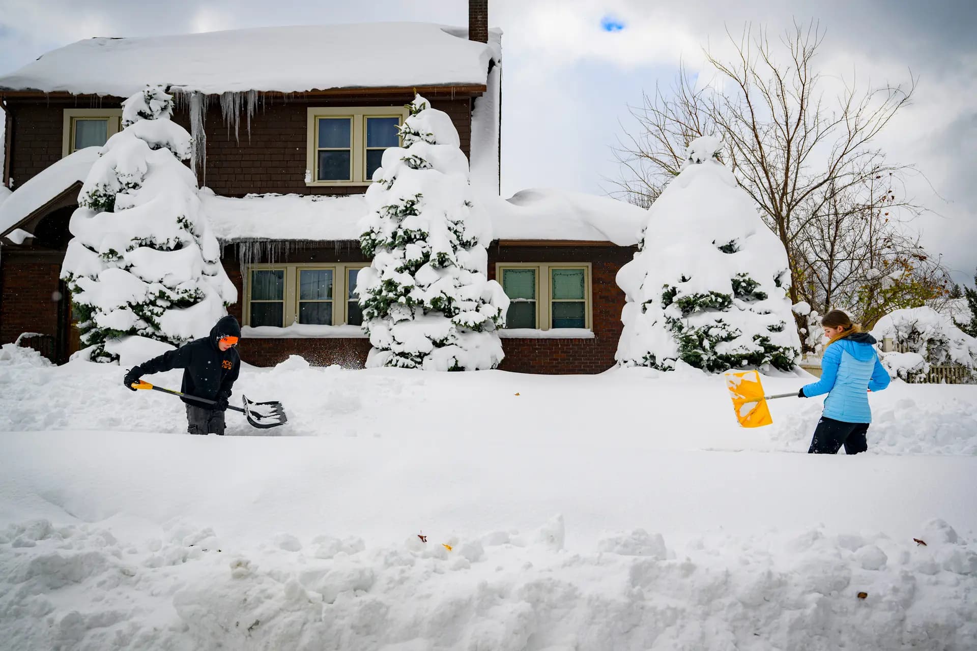 Dos adolescentes quitan la nieve de la acera frente a una de las casas de su tía en Erie, Pensilvania, el 2 de diciembre de 2024. Quitar la nieve es una de las muchas opciones laborales disponibles para los adolescentes. (Jeff Swensen/Getty Images).