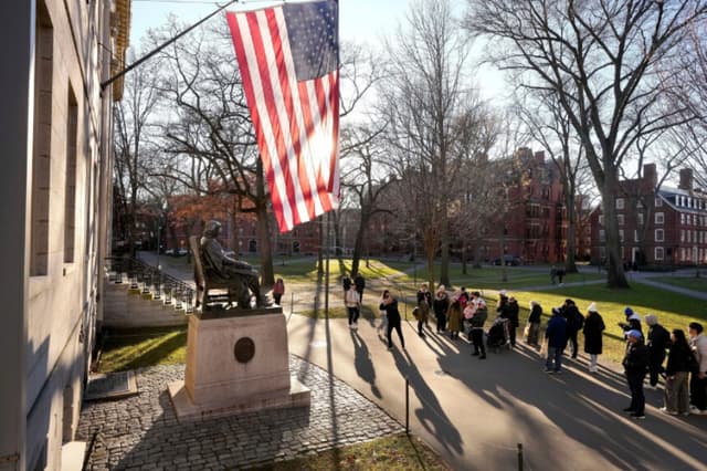 Varias personas fotografían una estatua de John Harvard (izq.) en el campus de la Universidad de Harvard, en Cambridge, Massachusetts, el 2 de enero de 2024. (Steven Senne/AP Photo).