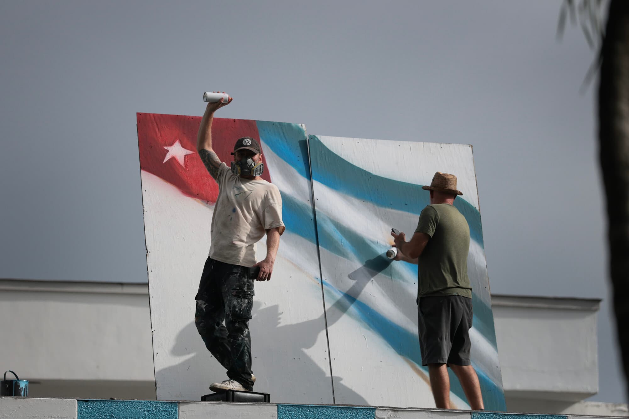 Un artista que pinta una bandera cubana observa durante la manifestación del Día de la Liberación, celebrada el 11 de julio de 2026 en Miami, Florida. La manifestación conmemora el quinto aniversario de las históricas protestas del 11 y 12 de julio en Cuba, las más grandes en décadas y que fueron reprimidas con dureza. (Joe Raedle/Getty Images)