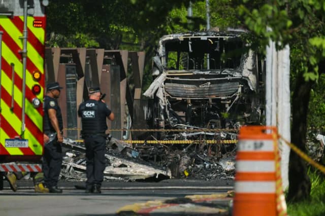 Agentes de la Guardia Municipal se encuentran frente a los restos de un autobús impactado, Brasil, el 7 de febrero de 2025. Imagen de Archivo (NELSON ALMEIDA/AFP vía Getty Images)