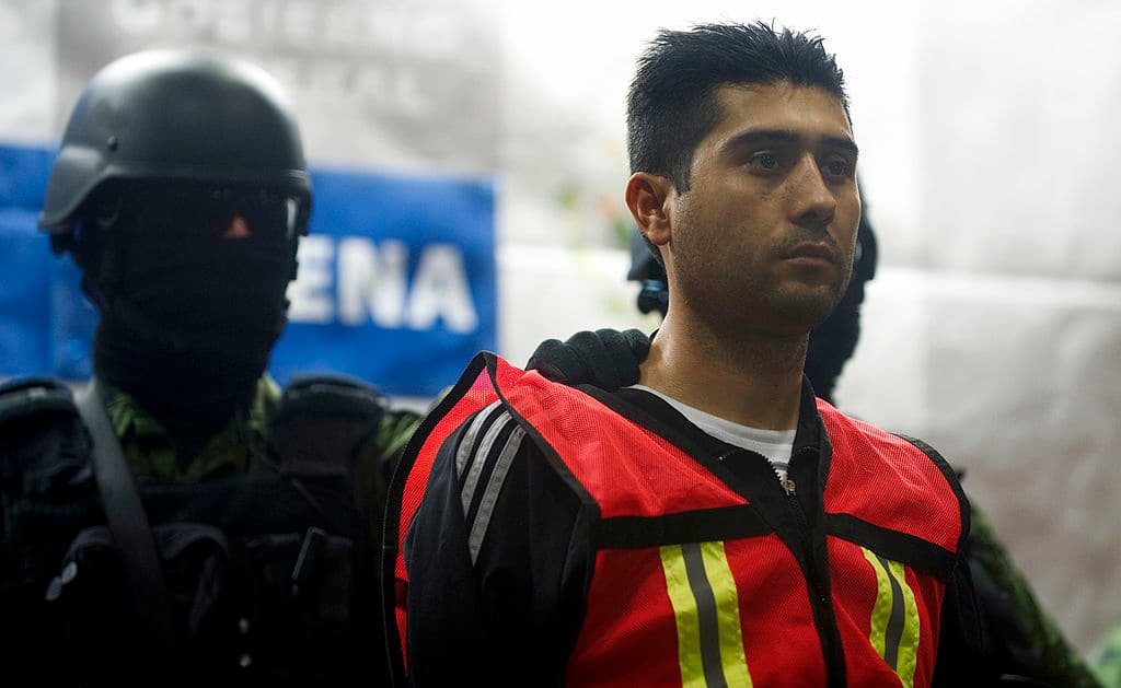 <em>Soldados mexicanos escoltan a Erick Valencia Salazar, alias "el 85", presunto líder del Cártel Jalisco Nueva Generación, durante su presentación ante la prensa el 12 de marzo de 2012 en la Ciudad de México. Valencia fue detenido el 9 de marzo durante un operativo militar en Guadalajara. (Yuri Cortez/AFP vía Getty Images)</em>