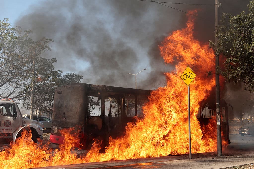 <em>Un autobús incendiado por grupos del crimen organizado en respuesta a un operativo en Jalisco. (Ulises RUIZ / AFP vía Getty Images)</em>