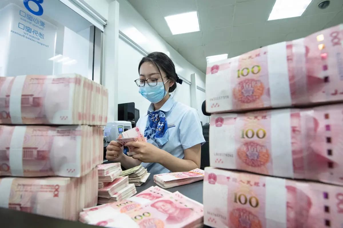 Un empleado bancario contando billetes de 100 yuanes en el mostrador de un banco en Nantong, en la provincia oriental de Jiangsu, China, el 13 de junio de 2023. (STR/AFP vía Getty Images).