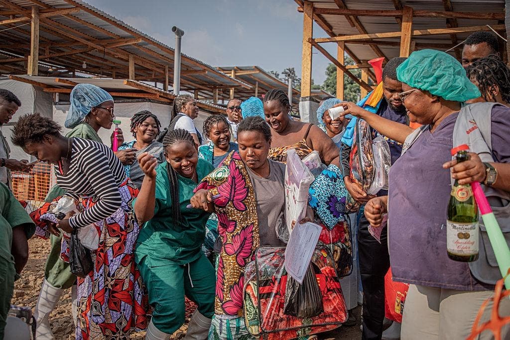 Los trabajadores de la salud celebran con los sobrevivientes de la enfermedad por el virus del Ébola al momento de salir del hospital, tras haber sido declarados curados, en Ituri, al este de la República Democrática del Congo, en el Centro de Tratamiento del Ébola (CTE) del Centro Médico Evangélico (CME), el 23 de junio de 2026. (Benediction Murhabazi/AFP vía Getty Images)