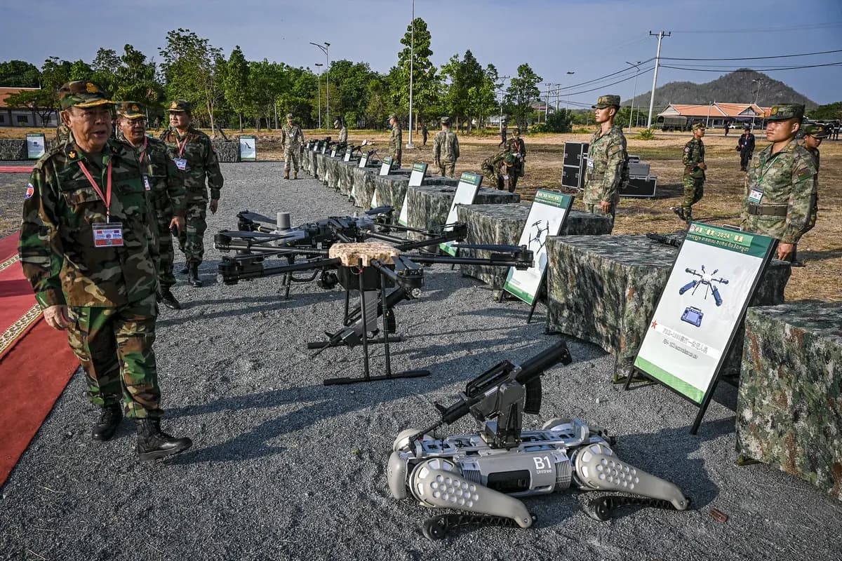 <em>Un oficial camboyano inspecciona drones y un robot "perro" de combate equipado con ametralladora que se exhiben a soldados chinos durante un ejercicio conjunto en una base de la policía militar en la provincia de Kampong Chhnang, Camboya, el 16 de mayo de 2024. (Tang Chhin Sothy/AFP vía Getty Images).</em>