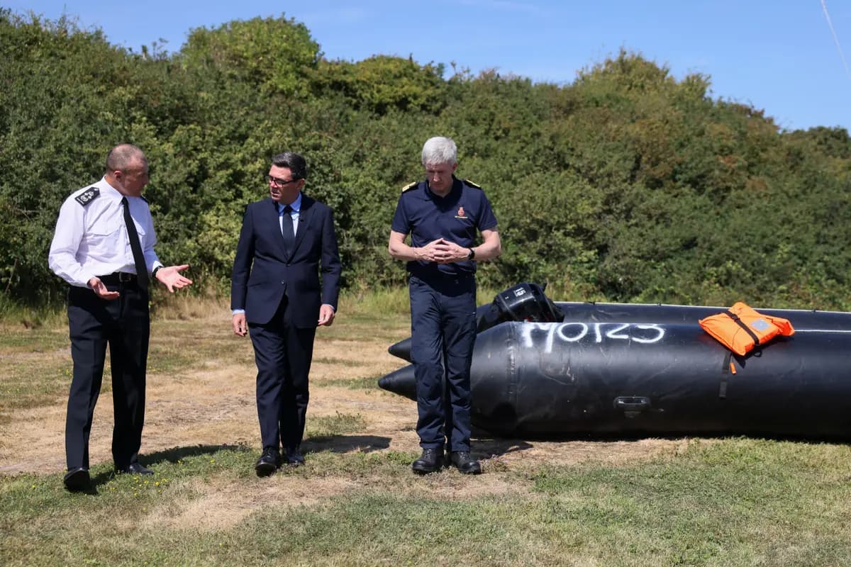 El primer ministro británico, Andy Burnham (C), conversa con John Craig, jefe interino del Servicio de Guardacostas, y con Duncan Capps, comandante de seguridad fronteriza (Izq.), junto a una pequeña embarcación recuperada que fue utilizada por inmigrantes ilegales para cruzar el Canal de la Mancha, durante una visita al Centro de Coordinación de Rescate Marítimo del Servicio de Guardacostas de Su Majestad, en Dover, Inglaterra, el 2 de agosto de 2026. (Jack Taylor/Foto de Pool vía AP).