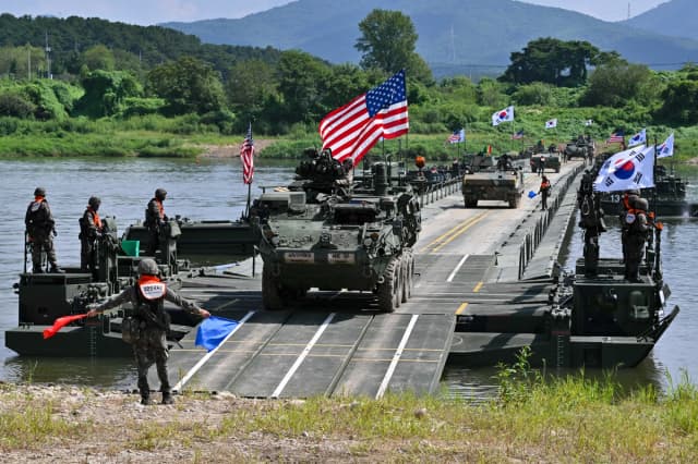 Un vehículo de transporte de infantería Stryker estadounidense (C) cruza un río sobre un puente flotante durante un ejercicio conjunto de cruce de río entre Estados Unidos y Corea del Sur, como parte del ejercicio militar anual Ulchi Freedom Shield en Yeoju, Corea del Sur, el 27 de agosto de 2025. (Jung Yeon-je/AFP vía Getty Images).