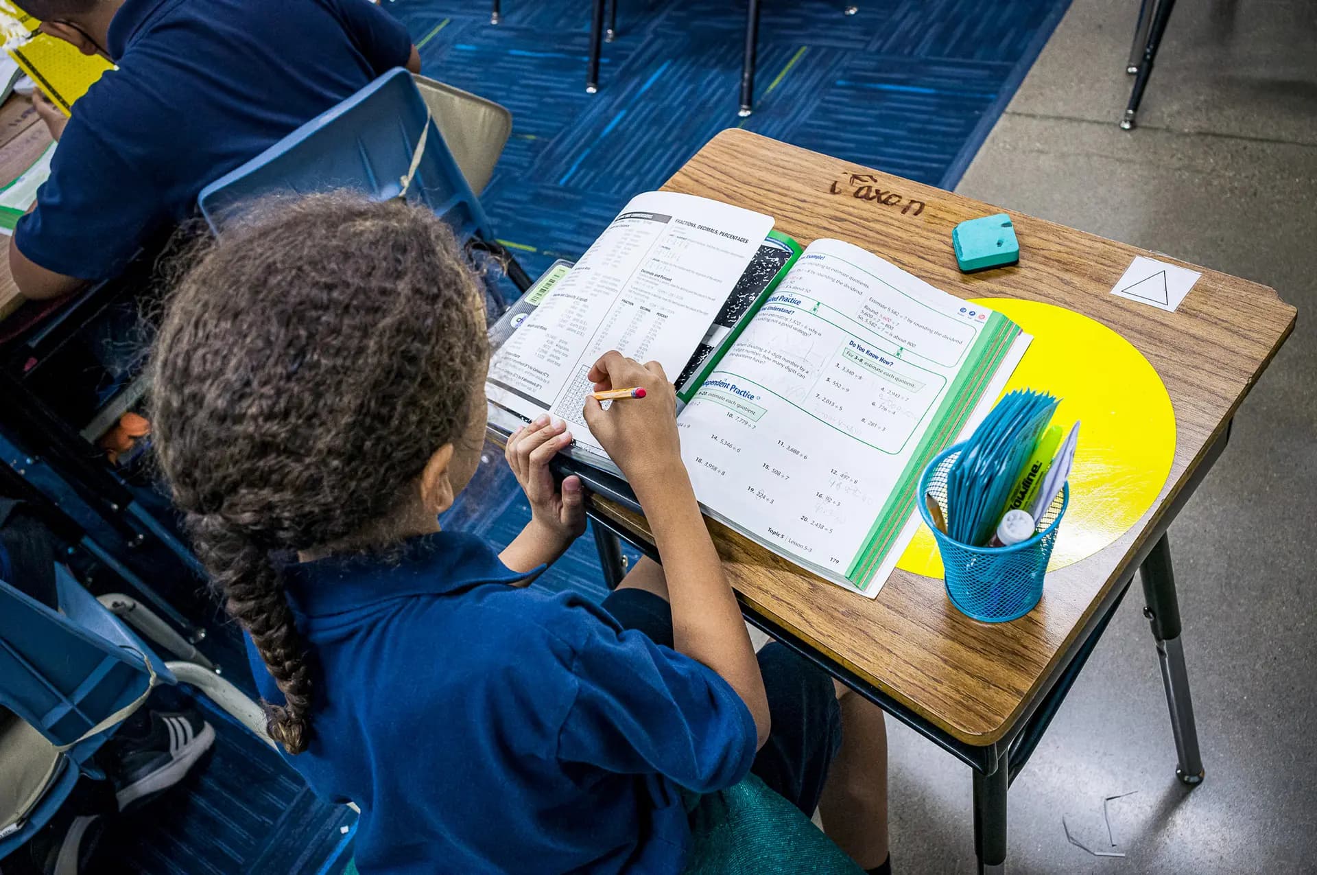 Una alumna estudia en un salón de clases de la Escuela Primaria Nevitt en Phoenix el 26 de octubre de 2022. Las investigaciones sugieren un mayor rendimiento académico y una mejor salud mental en los niños que asisten a escuelas con más tiempo de juego libre entre los bloques de clases. (Olivier Touron/AFP vía Getty Images)