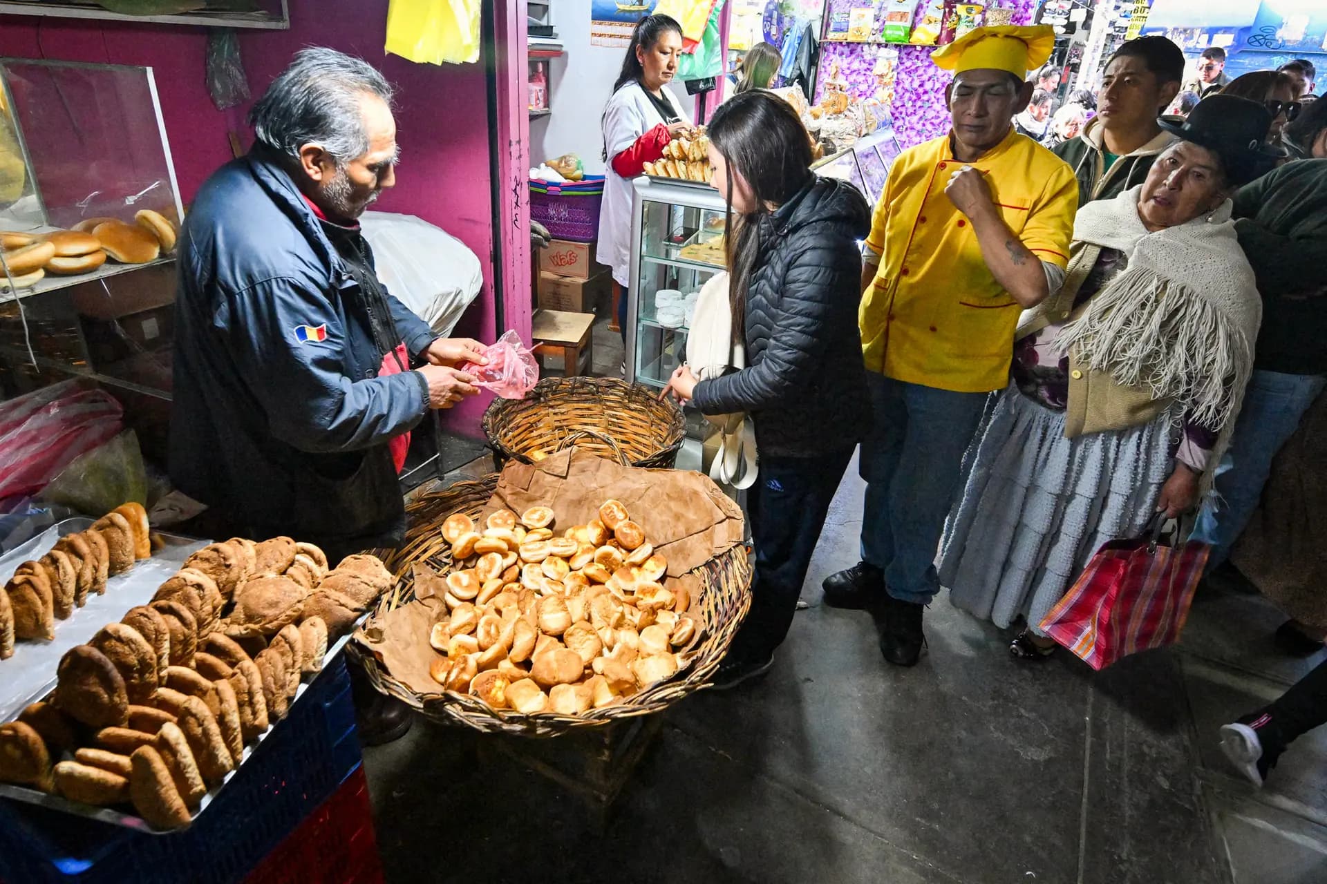 La gente hace fila para comprar pan en un mercado de La Paz, Bolivia, el 31 de julio de 2025. Antes de las elecciones de Bolivia en 2025, el pan se convirtió en un símbolo de una grave crisis económica, ya que los panaderos redujeron el tamaño de las barras de pan en medio de la inflación y una escasez de efectivo que paralizó las importaciones de harina, mientras que el precio fijado por el gobierno se mantuvo igual. (Aizar Raldes/AFP vía Getty Images)