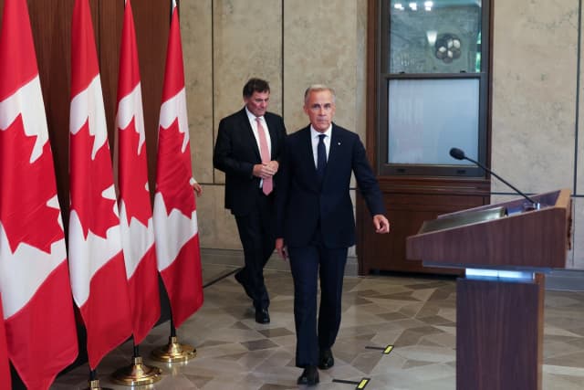 El primer ministro canadiense, Mark Carney, y Dominic LeBlanc, ministro a cargo del comercio entre Canadá y EE. UU., llegan a una conferencia de prensa tras el fracaso de las negociaciones comerciales con EE. UU. en Ottawa, Canadá, el 22 de agosto de 2026. (Dave Chan/AFP vía Getty Images)