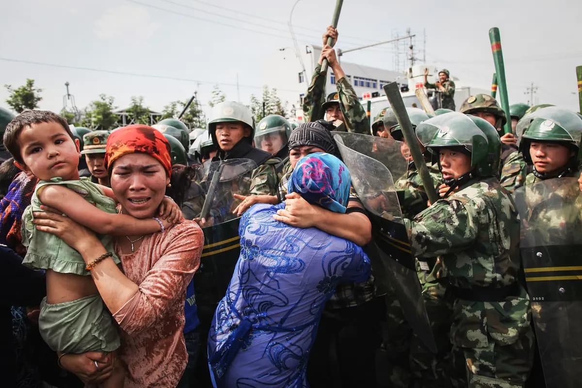 Policías chinos empujan a mujeres uigures que protestan en una calle de Urumqi, la capital de la Región Autónoma Uigur de Xinjiang, China, el 7 de julio de 2009. (Guang Niu/Getty Images)