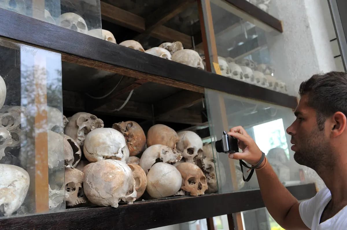 Un turista toma fotos de calaveras de víctimas del Khmer Rouge expuestas en el memorial de los campos de exterminio de Choeung Ek, en Phnom Penh, el 4 de mayo de 2011. El régimen comunista de Camboya mató a casi un tercio de la población del país. (Tang Chhin Sothy/AFP/Getty Images)
